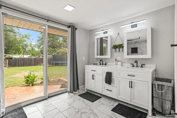 a spacious bathroom with a double vanity sink and a large mirror