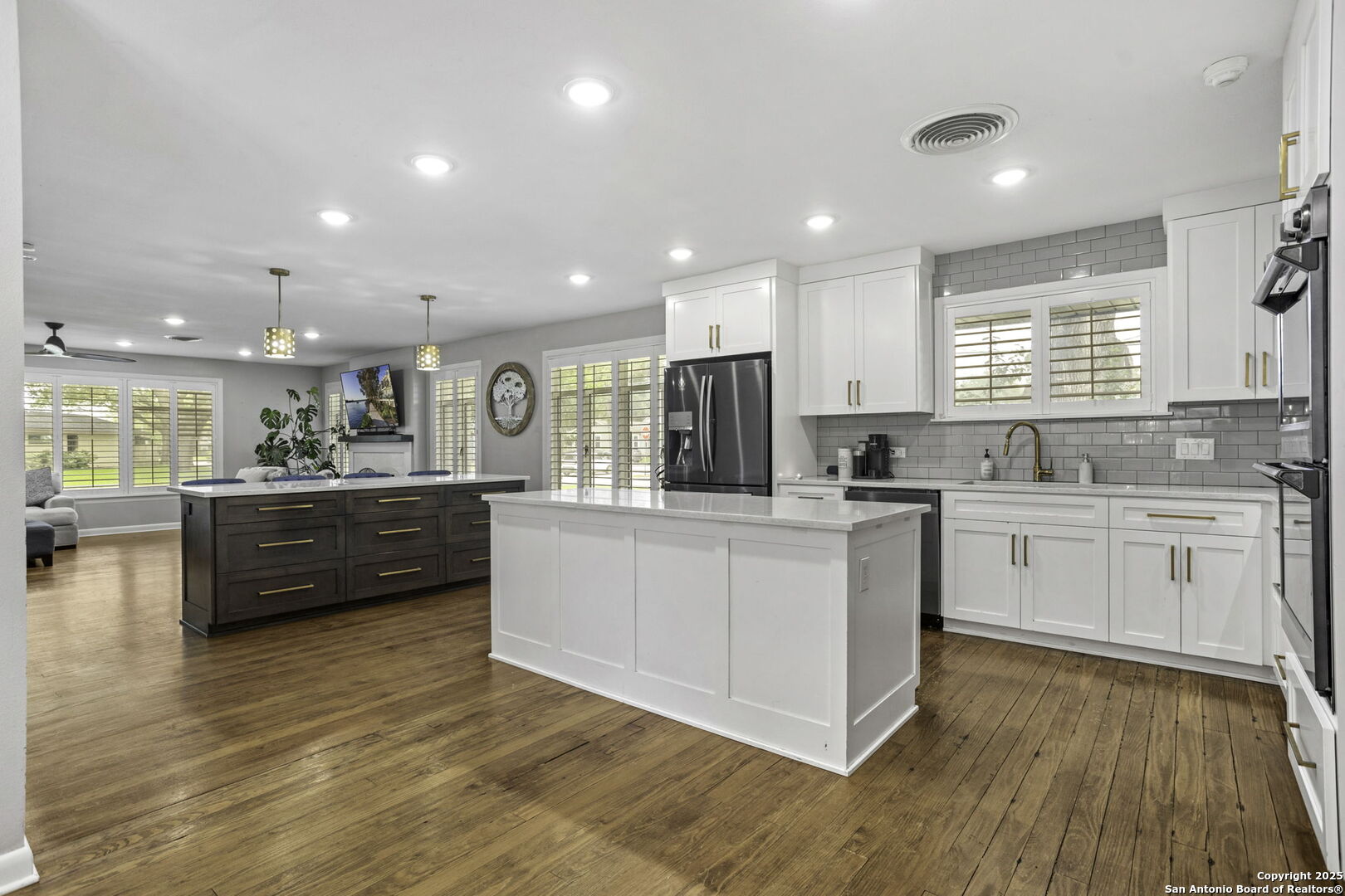 906 East Cedar Street Seguin, TX 78155 - Photo 11 of 22 a kitchen with stainless steel appliances wooden floors and white cabinets