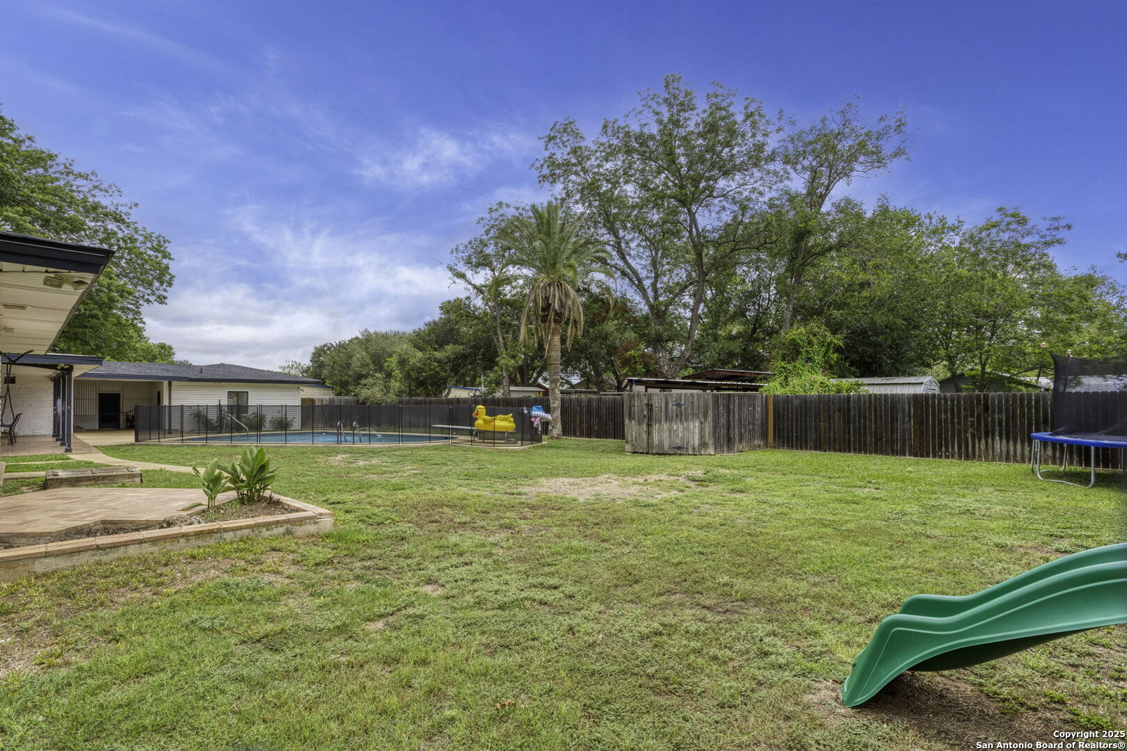 906 East Cedar Street Seguin, TX 78155 - Photo 17 of 17 a view of a backyard with plants and wooden fence