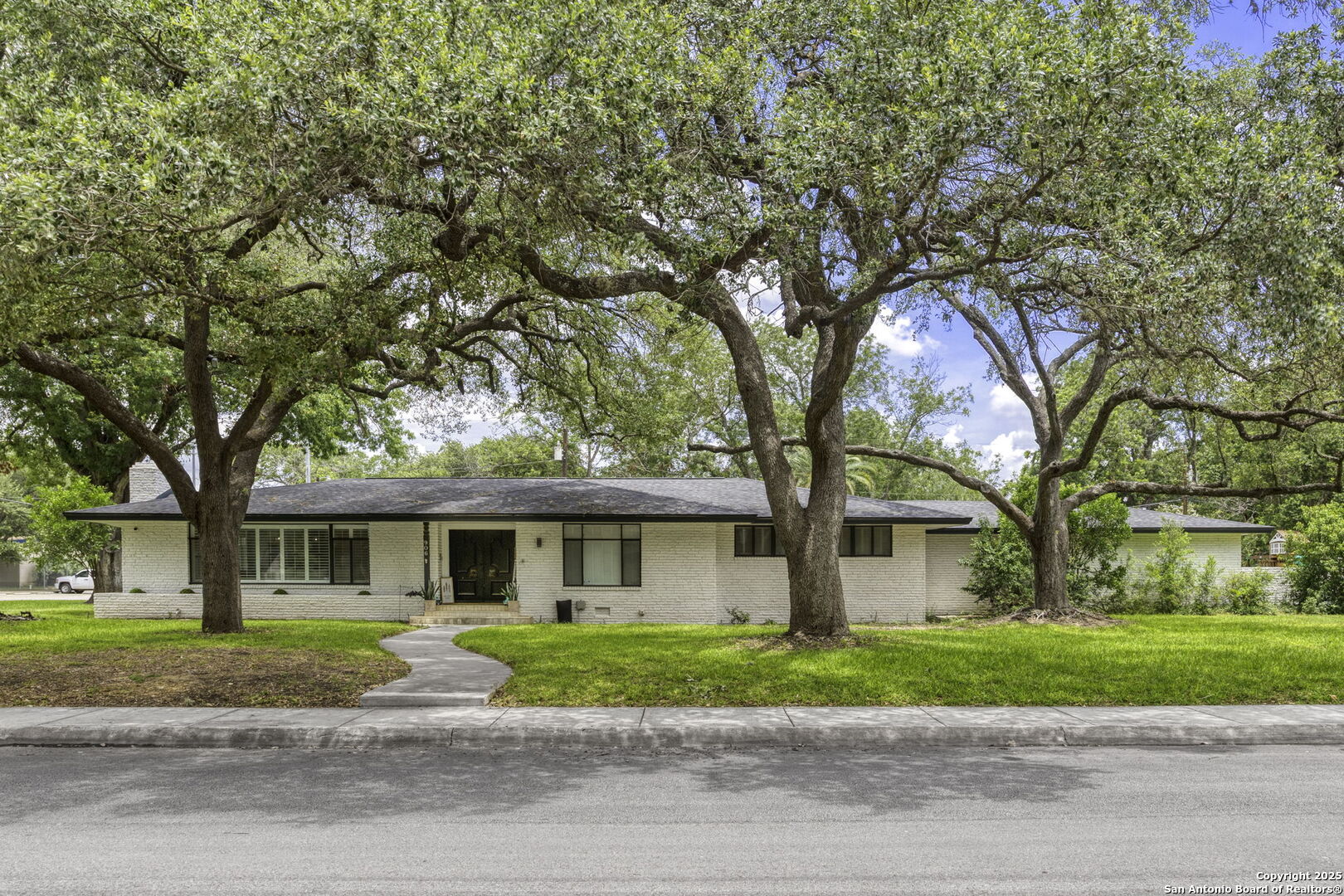 906 East Cedar Street Seguin, TX 78155 - Photo 2 of 22 a front view of a house with a garden and trees