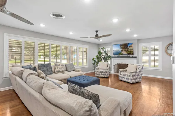 a living room with fireplace furniture and a large window