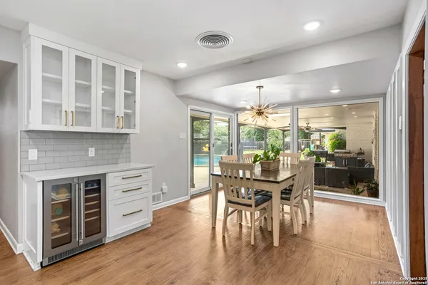 a dining room with furniture a floor to ceiling window and wooden floor