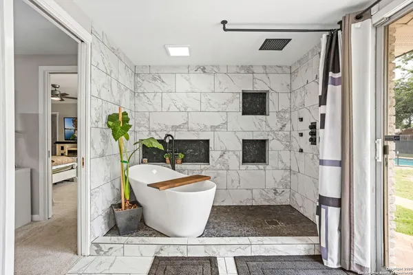 a white bath tub sitting in a bathroom next to a window