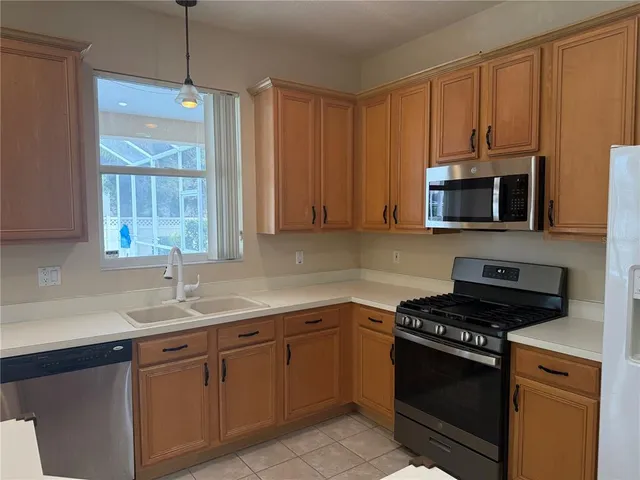 a kitchen with granite countertop a stove a sink and wooden cabinets