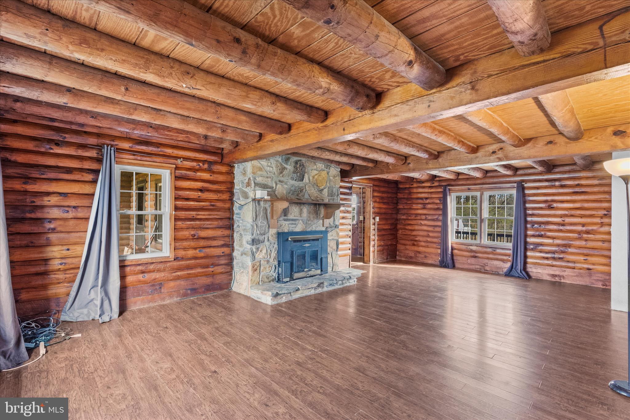 181 Gooseville Road New Oxford, PA 17350 - Photo 11 of 45 an empty room with wooden floor fireplace and windows