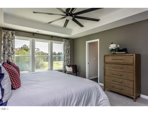 a bedroom with a bed a dresser and a chandelier