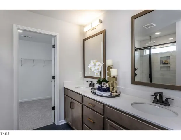 a bathroom with double vanity sinks and a mirror