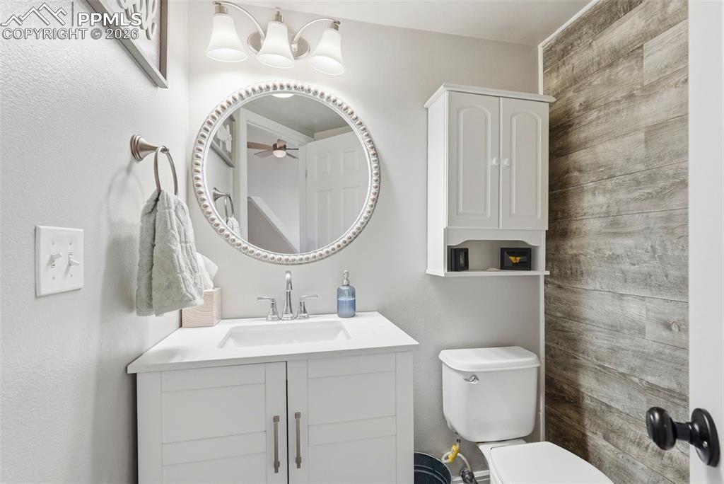6907 Shimmering Leaf Road Colorado Springs, CO 80908 - Photo 19 of 49 a bathroom with a sink a mirror a toilet and a shower
