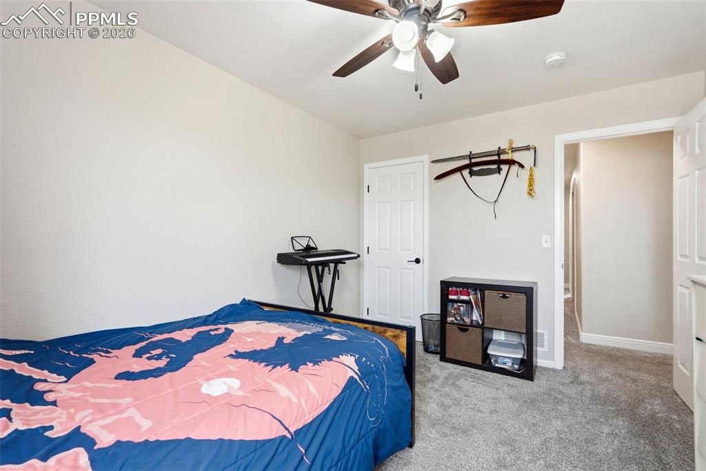 6907 Shimmering Leaf Road Colorado Springs, CO 80908 - Photo 26 of 49 a bedroom with a bed and a chandelier