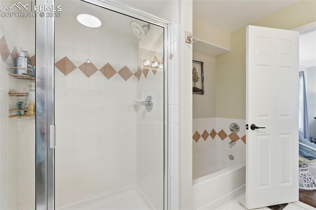6907 Shimmering Leaf Road Colorado Springs, CO 80908 - Photo 35 of 49 a bathroom with a bathtub and shower