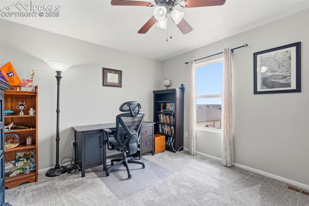 6907 Shimmering Leaf Road Colorado Springs, CO 80908 - Photo 36 of 49 a view of a workspace with furniture and a ceiling fan