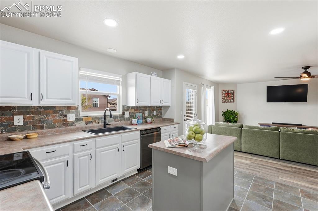 6907 Shimmering Leaf Road Colorado Springs, CO 80908 - Photo 8 of 49 a kitchen with stainless steel appliances a sink a stove a refrigerator cabinets and a window