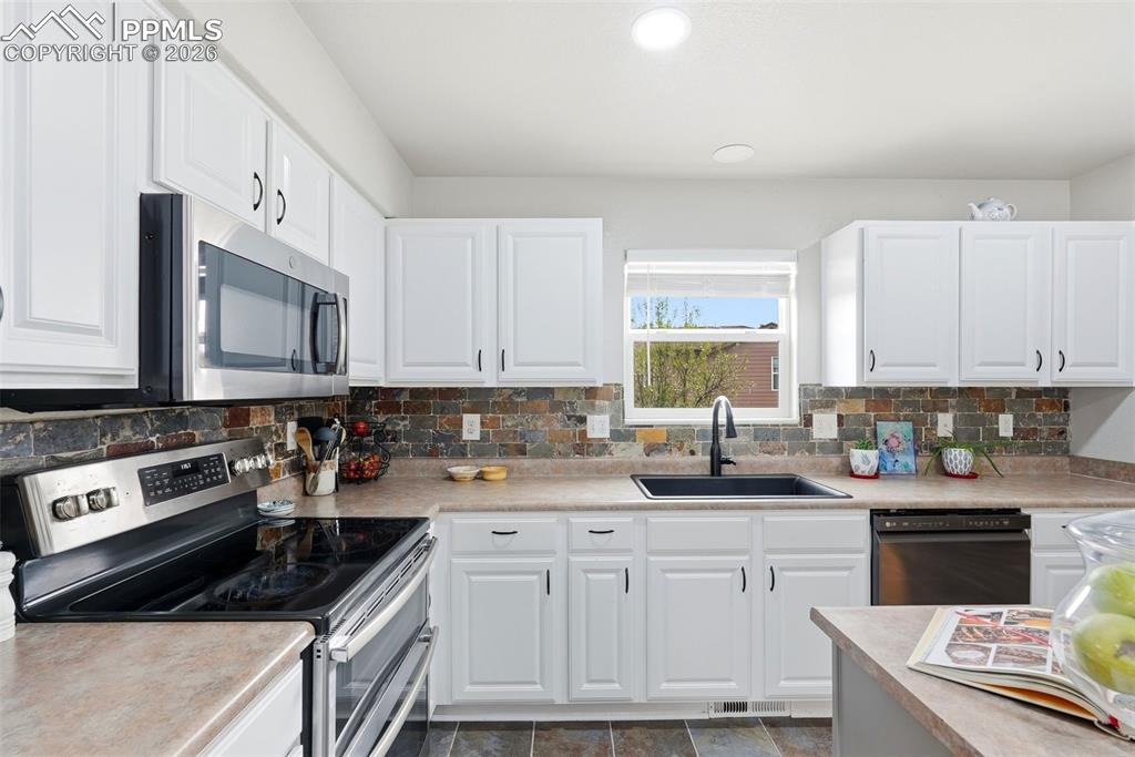 6907 Shimmering Leaf Road Colorado Springs, CO 80908 - Photo 9 of 49 a kitchen with granite countertop a sink a stove and cabinets