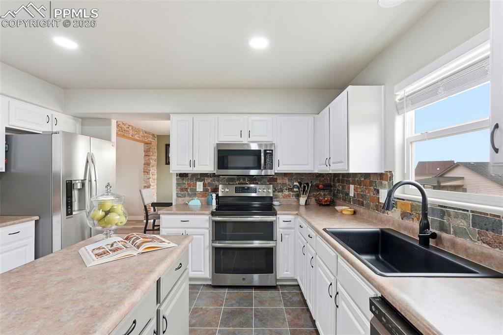 6907 Shimmering Leaf Road Colorado Springs, CO 80908 - Photo 10 of 49 a kitchen with a sink stove and refrigerator