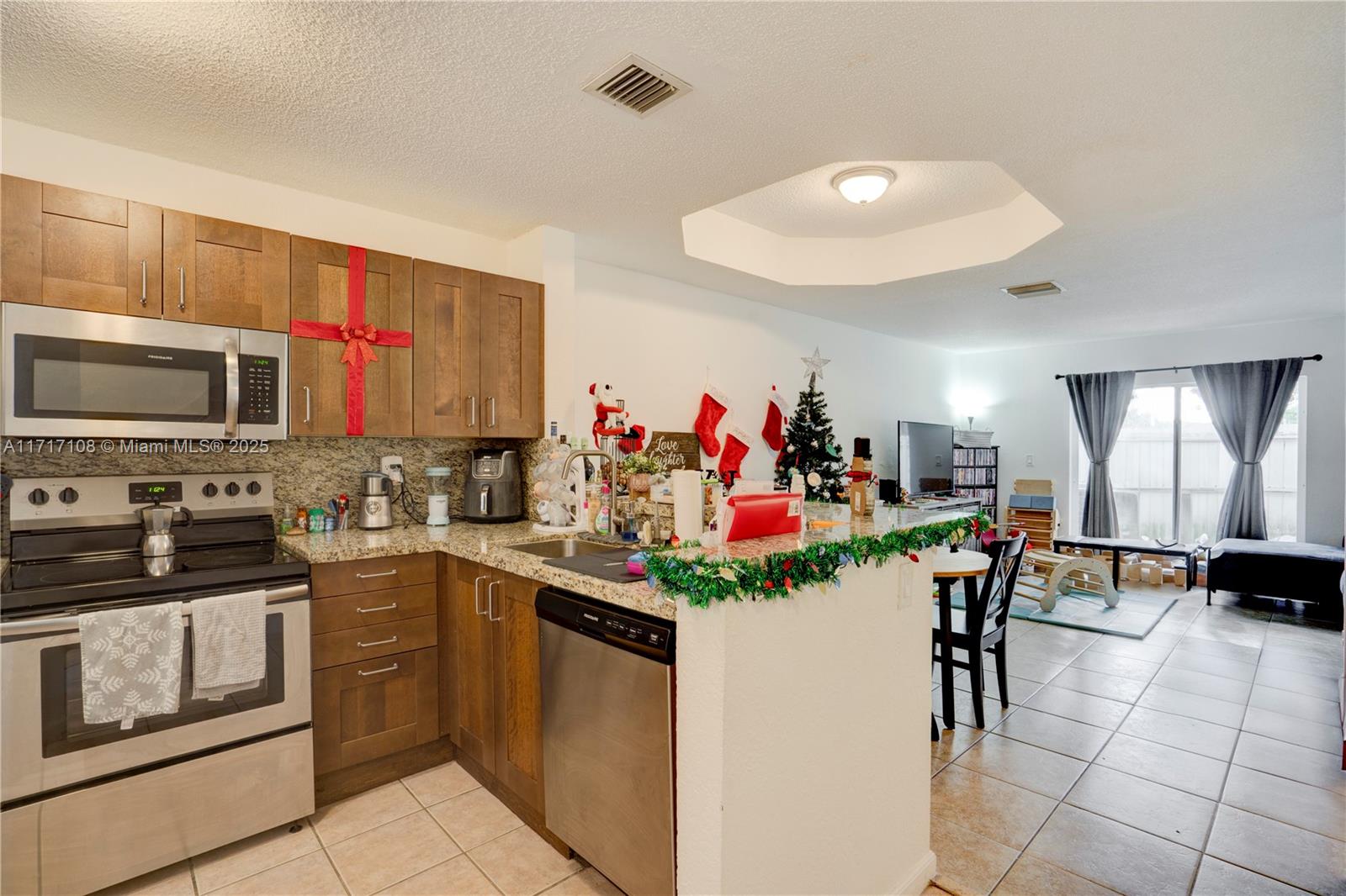 12124 Southwest 143rd Lane, Unit 85 Miami, FL 33186 - Photo 21 of 44 a view of a kitchen with kitchen island granite countertop stainless steel appliances stove microwave and cabinets