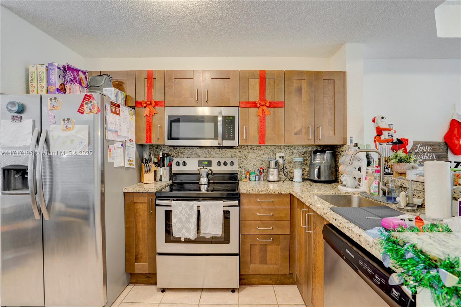 12124 Southwest 143rd Lane, Unit 85 Miami, FL 33186 - Photo 22 of 44 a kitchen with stainless steel appliances granite countertop a refrigerator and a stove top oven