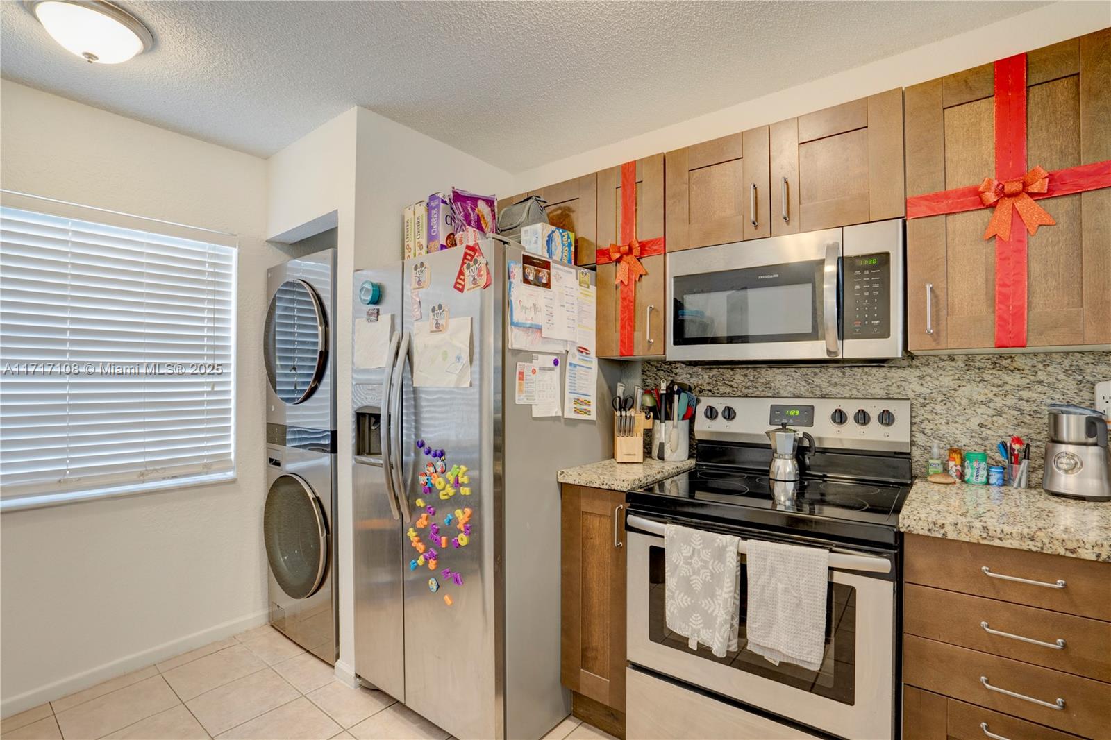 12124 Southwest 143rd Lane, Unit 85 Miami, FL 33186 - Photo 23 of 44 a kitchen with stainless steel appliances granite countertop a refrigerator and a stove top oven