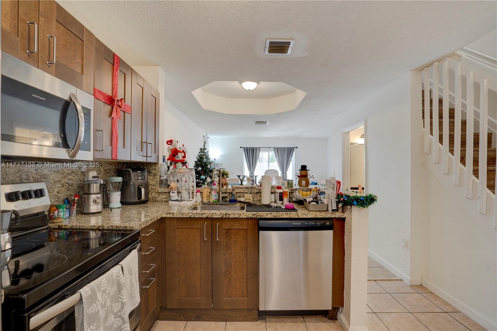 12124 Southwest 143rd Lane, Unit 85 Miami, FL 33186 - Photo 27 of 44 a kitchen with stainless steel appliances a sink stove and cabinets