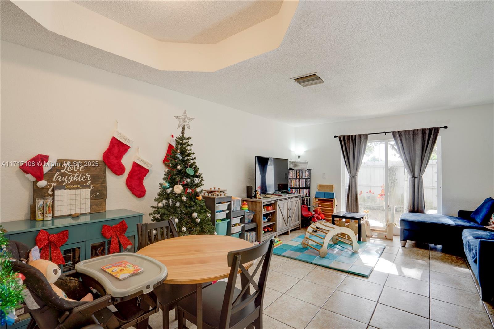 12124 Southwest 143rd Lane, Unit 85 Miami, FL 33186 - Photo 28 of 44 a view of a dining room with furniture and a flat screen tv