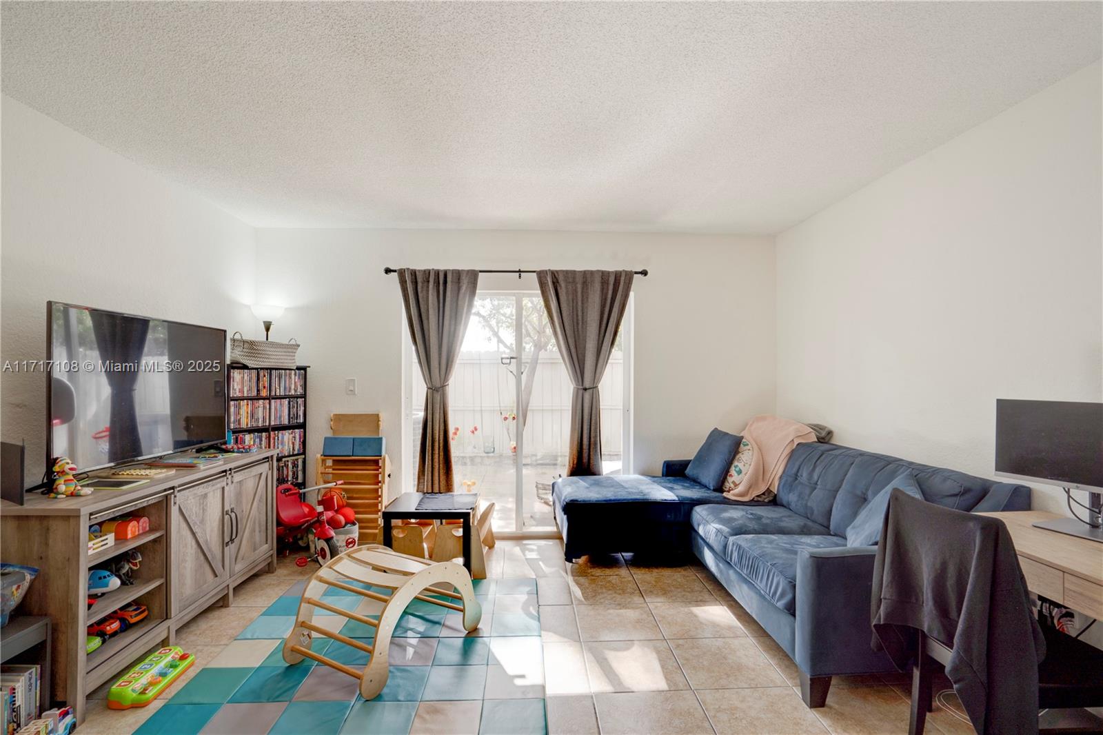 12124 Southwest 143rd Lane, Unit 85 Miami, FL 33186 - Photo 29 of 44 a living room with furniture and a flat screen tv