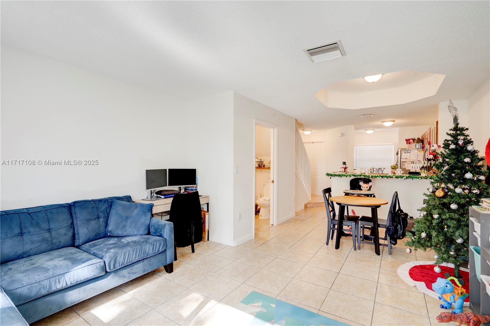 12124 Southwest 143rd Lane, Unit 85 Miami, FL 33186 - Photo 31 of 44 a living room with furniture and a dining table with kitchen view