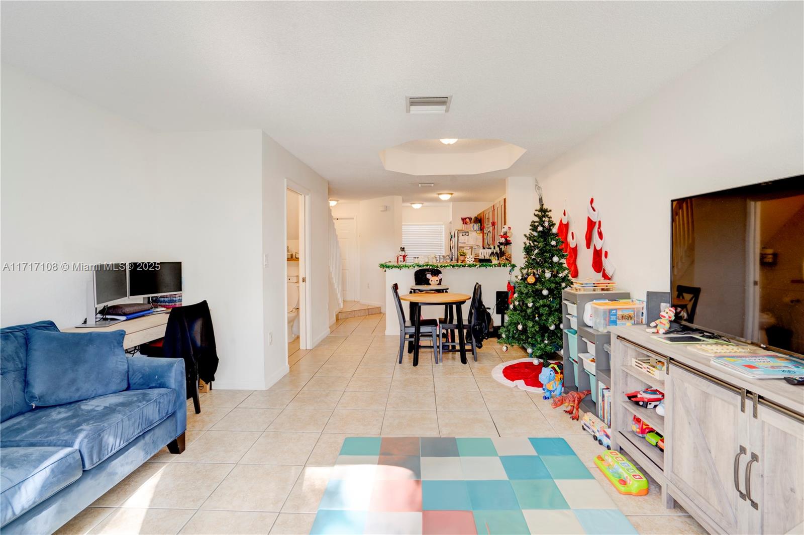 12124 Southwest 143rd Lane, Unit 85 Miami, FL 33186 - Photo 32 of 44 a living room with furniture and a flat screen tv