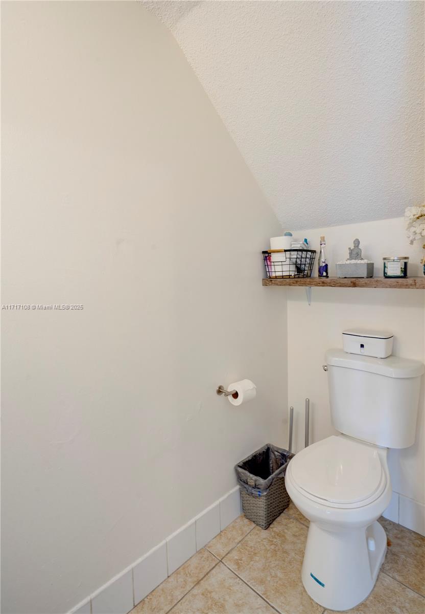 12124 Southwest 143rd Lane, Unit 85 Miami, FL 33186 - Photo 36 of 44 a bathroom with a toilet and a wooden floor