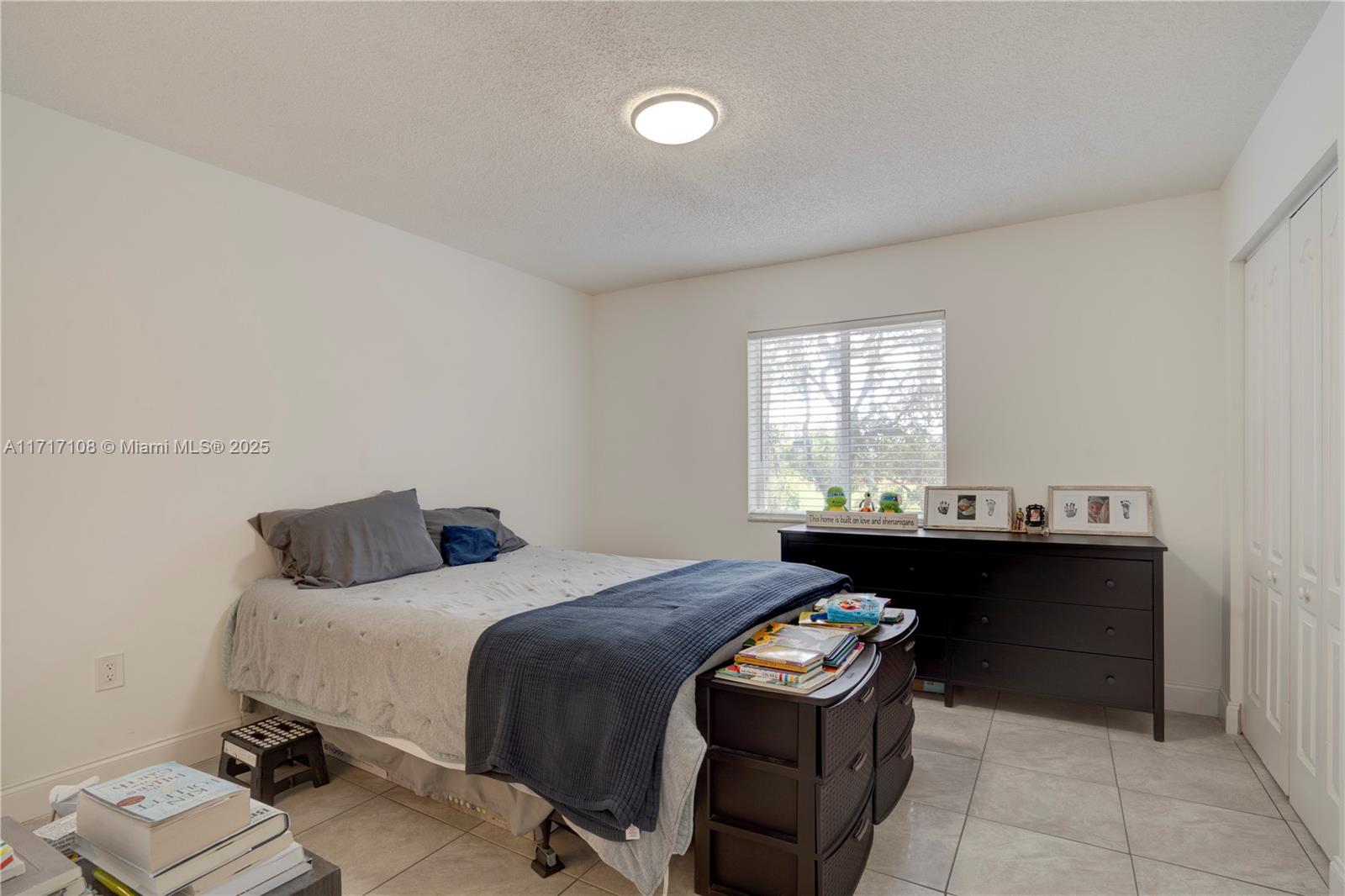 12124 Southwest 143rd Lane, Unit 85 Miami, FL 33186 - Photo 40 of 44 a bedroom with a bed and a window