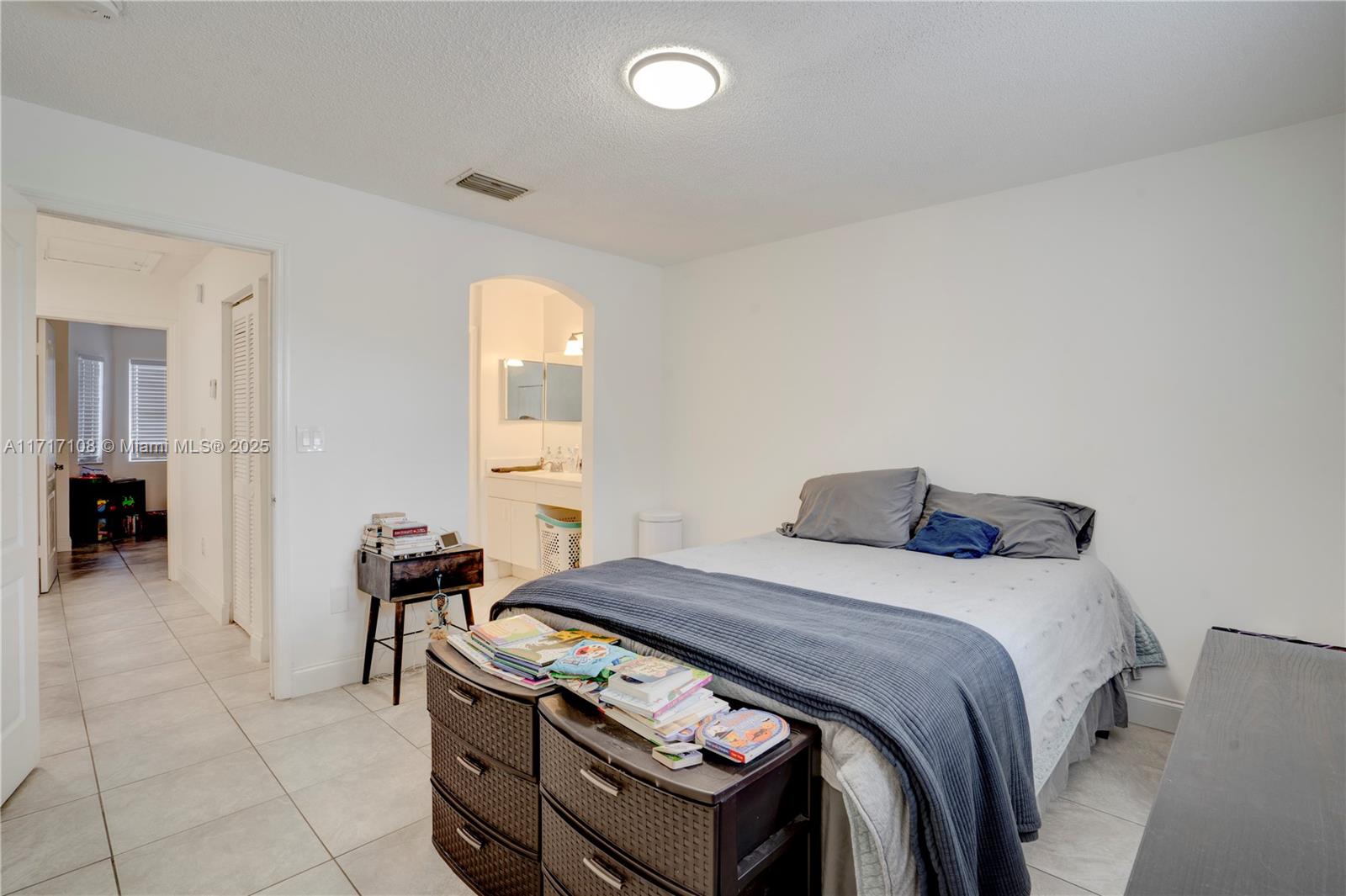 12124 Southwest 143rd Lane, Unit 85 Miami, FL 33186 - Photo 42 of 44 a bedroom with a bed and a table