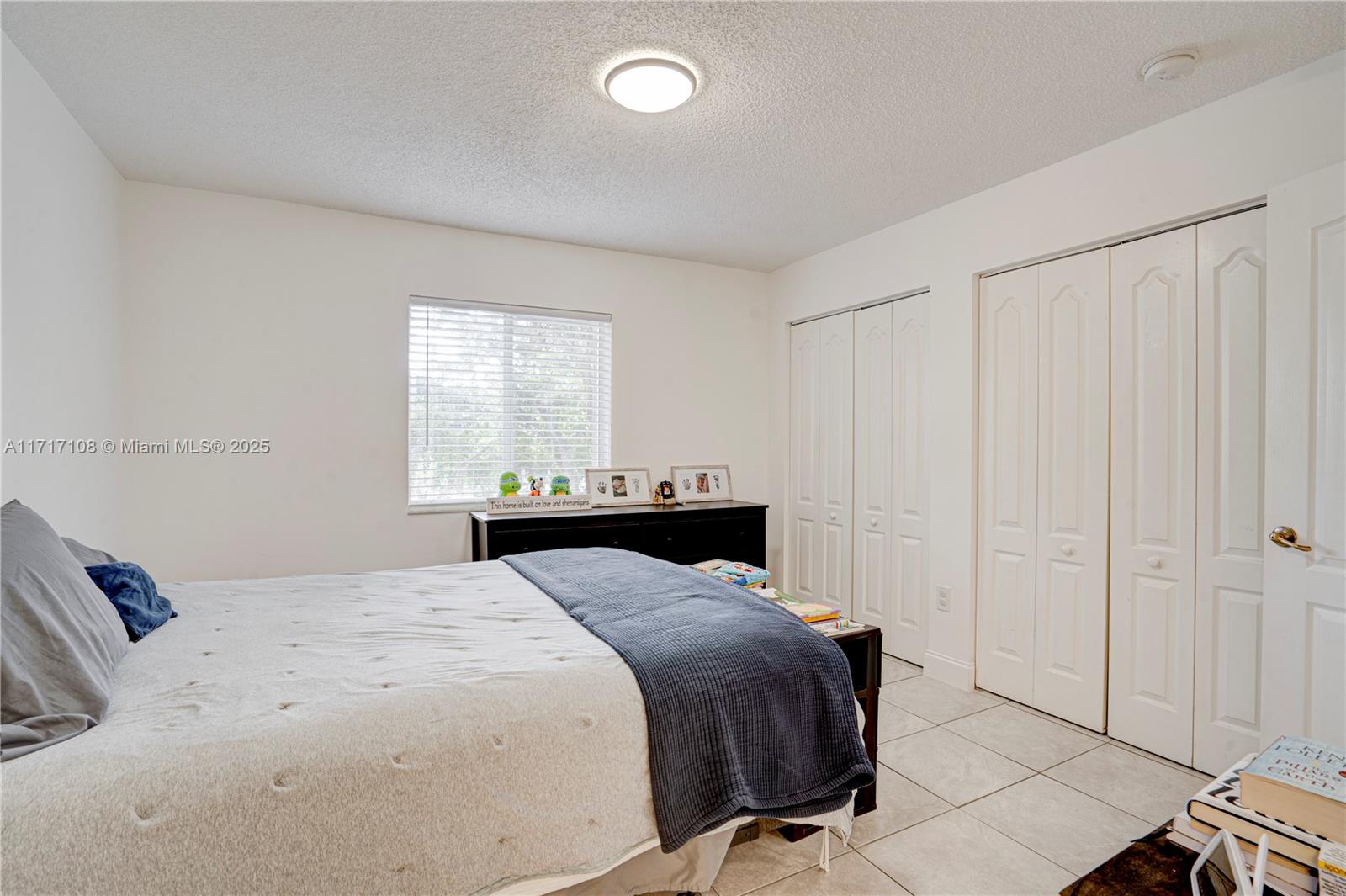 12124 Southwest 143rd Lane, Unit 85 Miami, FL 33186 - Photo 43 of 44 a bedroom with a bed and a window