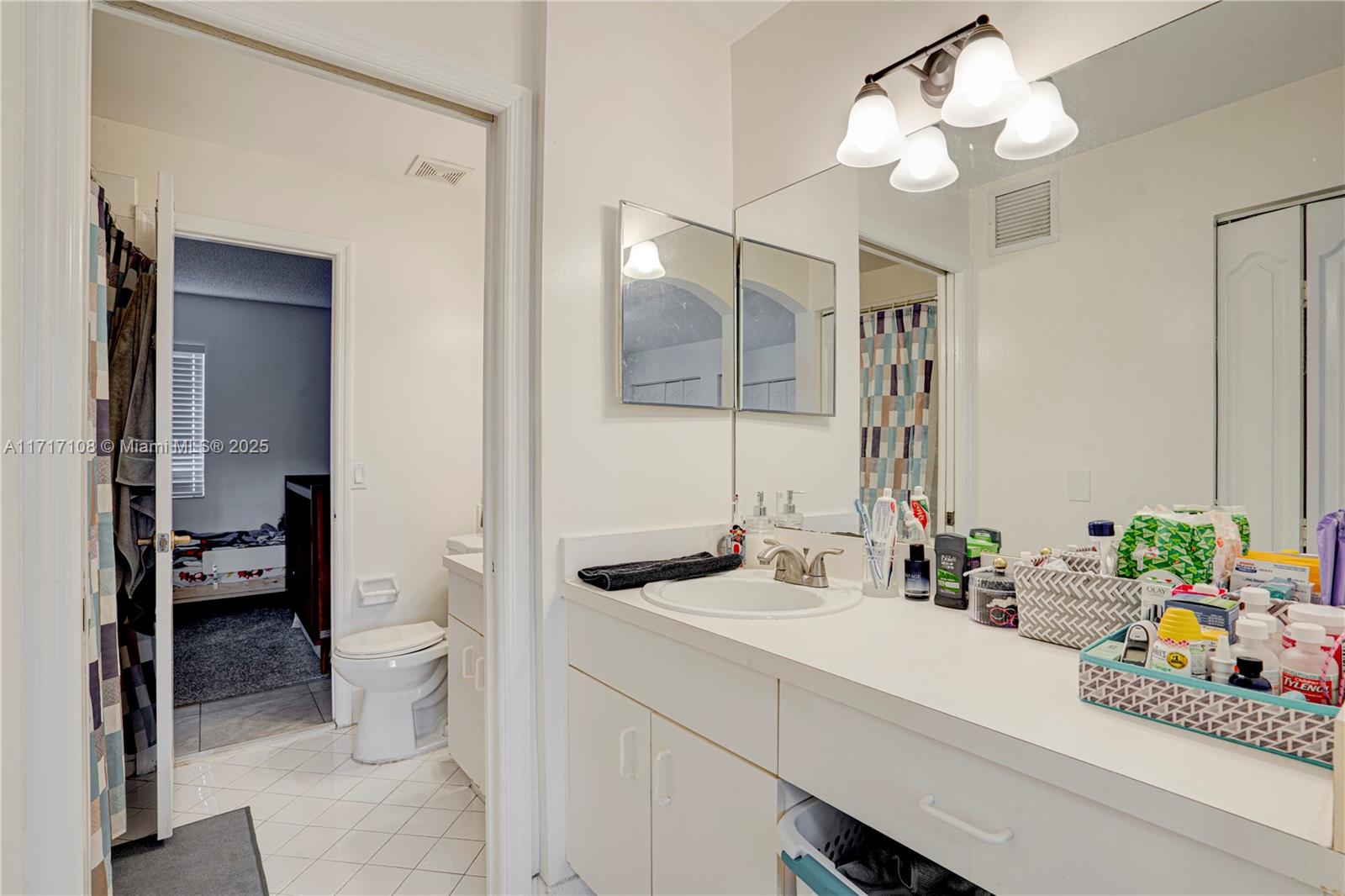 12124 Southwest 143rd Lane, Unit 85 Miami, FL 33186 - Photo 44 of 44 a bathroom with a sink a toilet and a mirror