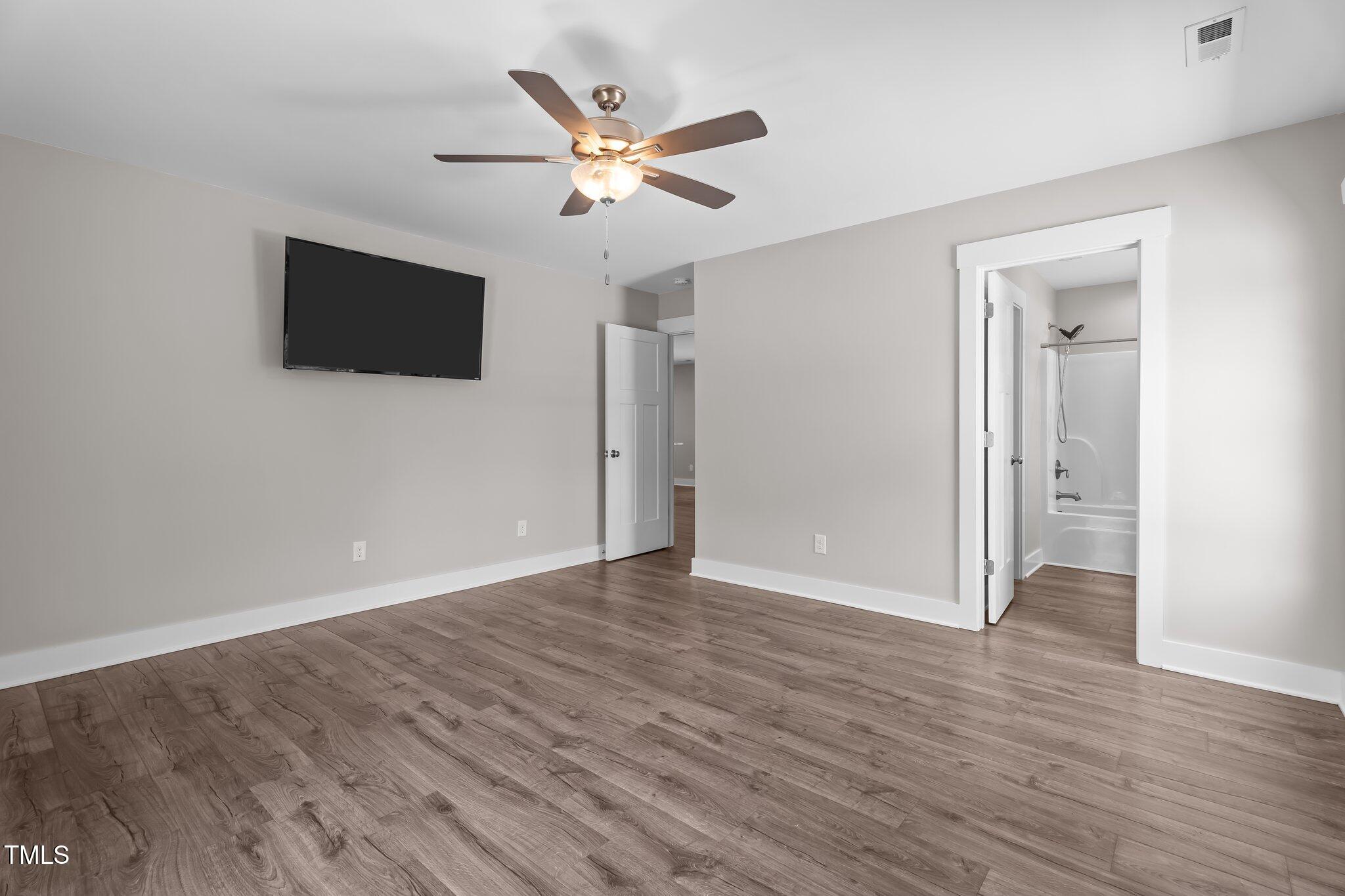 1914 Jack Road Clayton, NC 27520 - Photo 18 of 38 a view of an empty room with wooden floor and a ceiling fan