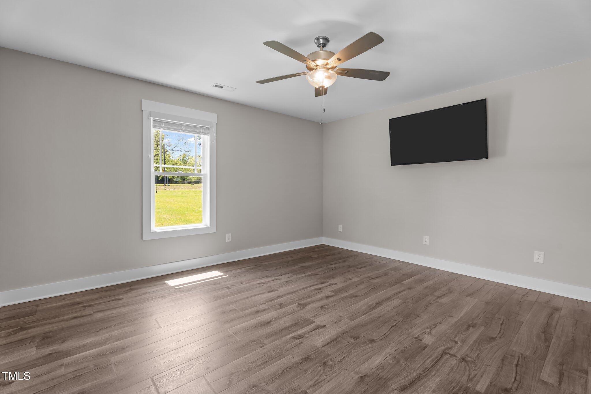 1914 Jack Road Clayton, NC 27520 - Photo 19 of 38 an empty room with wooden floor and windows