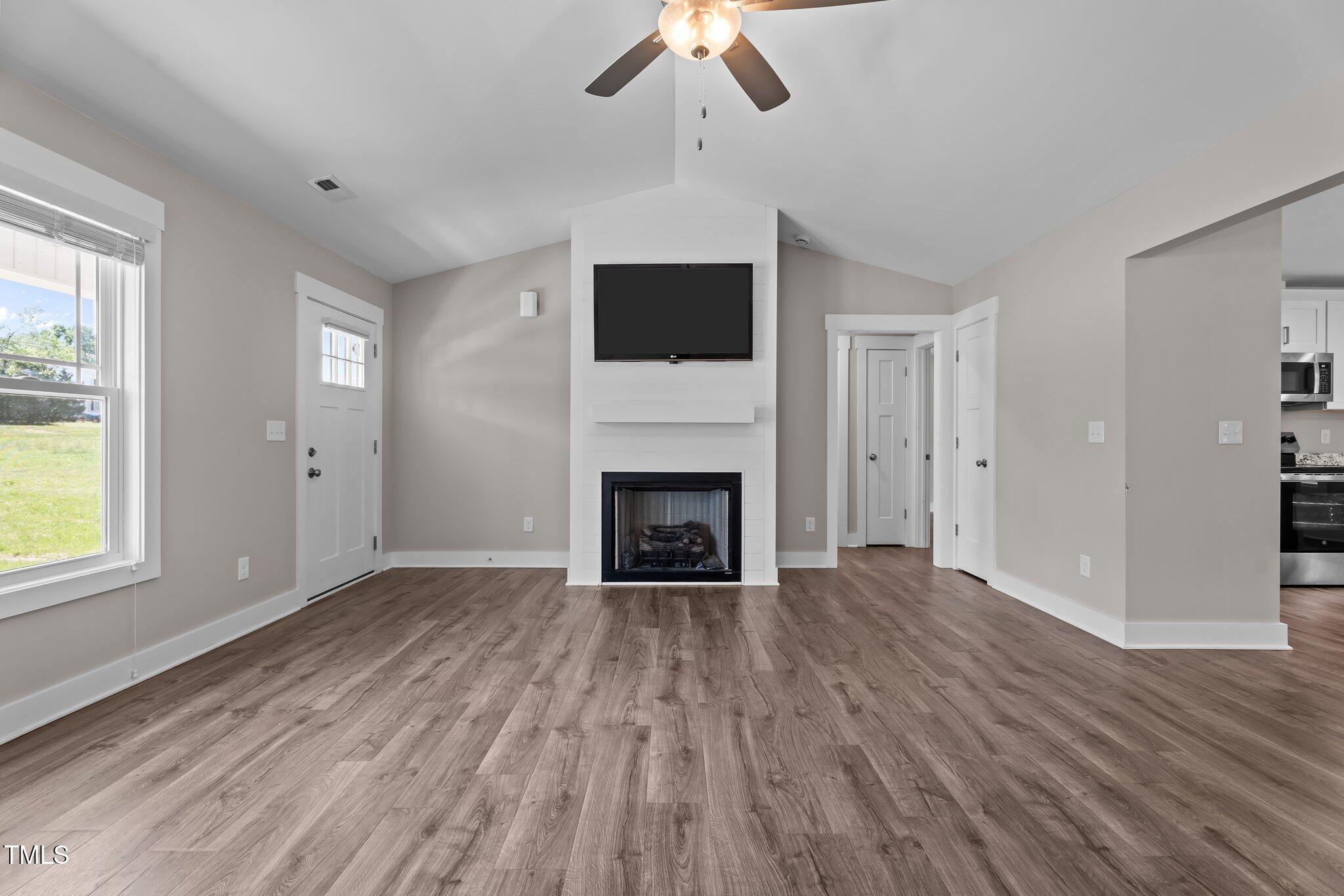 1914 Jack Road Clayton, NC 27520 - Photo 26 of 38 wooden floor fireplace and windows in an empty room