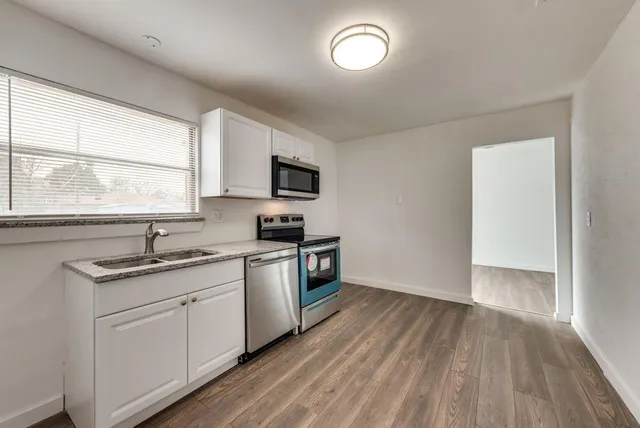 a kitchen with a sink a window and appliances