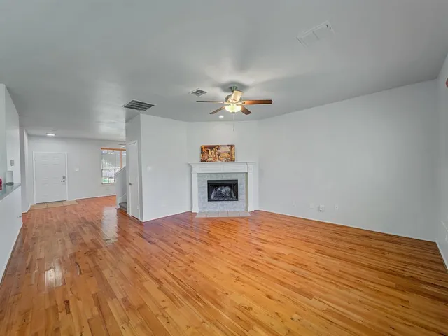 a view of an empty room with a window and fireplace