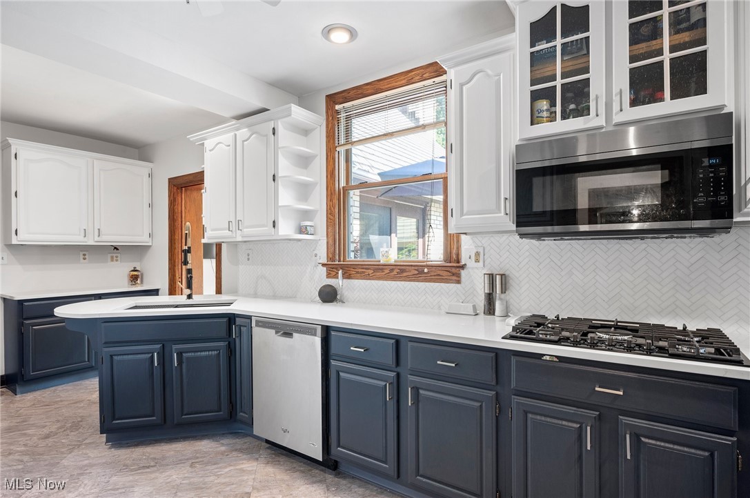 2213 Coventry Road Cleveland, OH 44118 - Photo 20 of 46 Kitchen with appliances with stainless steel finishes, decorative backsplash, blue cabinets, white cabinetry, and sink