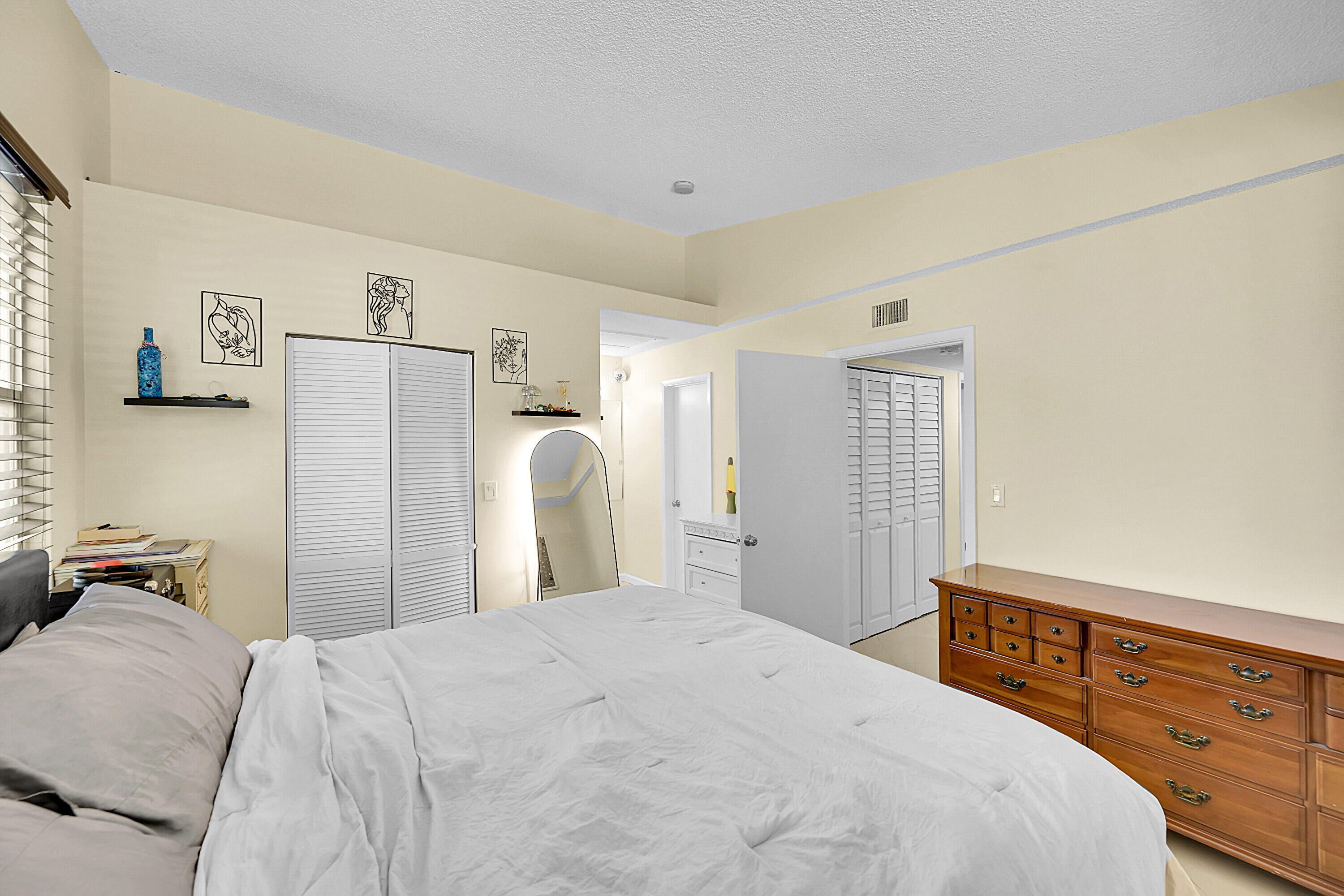 931 Lyons Road, Unit 4201 Coconut Creek, FL 33063 - Photo 11 of 47 a bedroom with a bed and a dresser