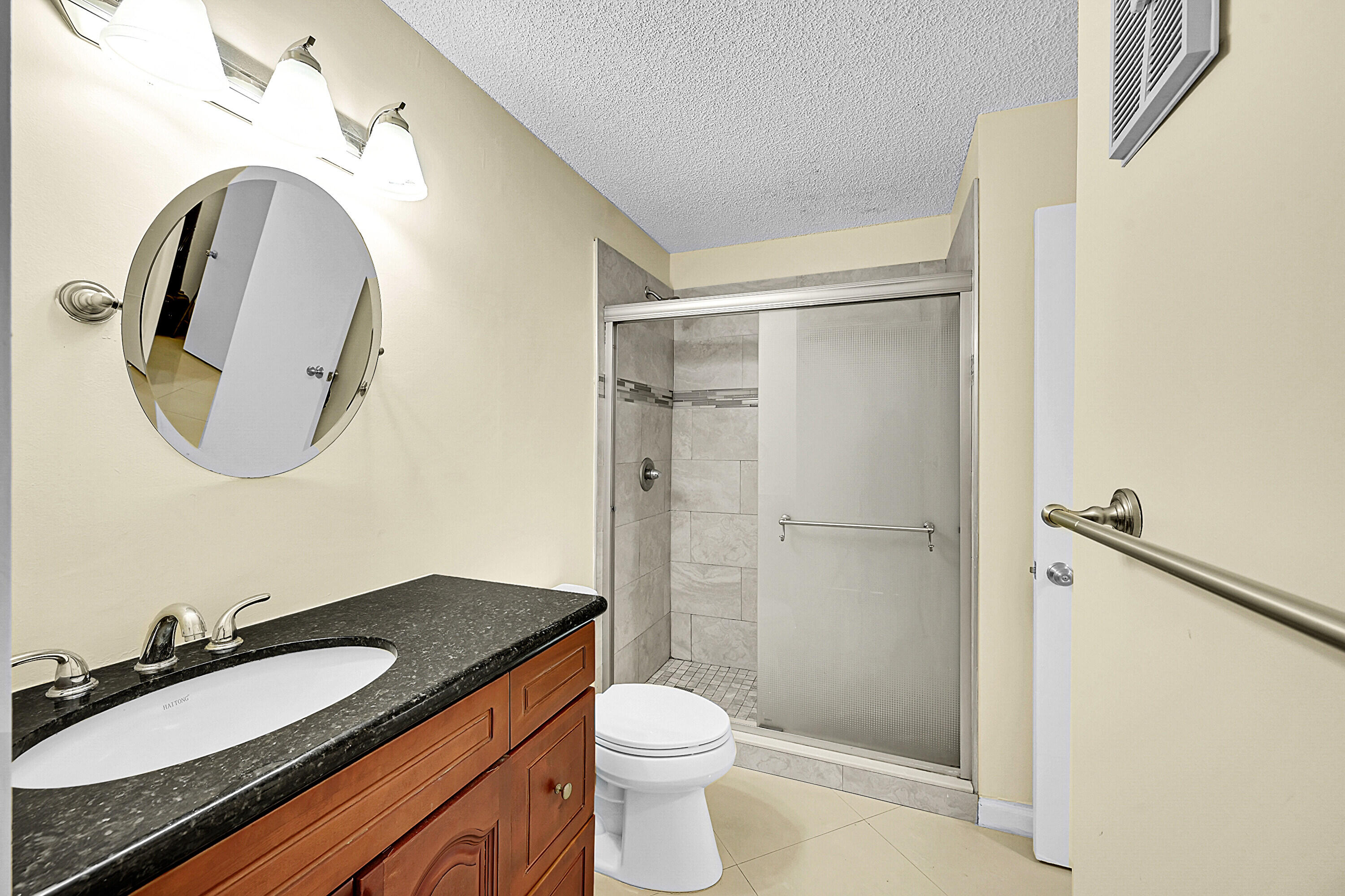 931 Lyons Road, Unit 4201 Coconut Creek, FL 33063 - Photo 14 of 47 a bathroom with a granite countertop sink toilet a mirror and shower