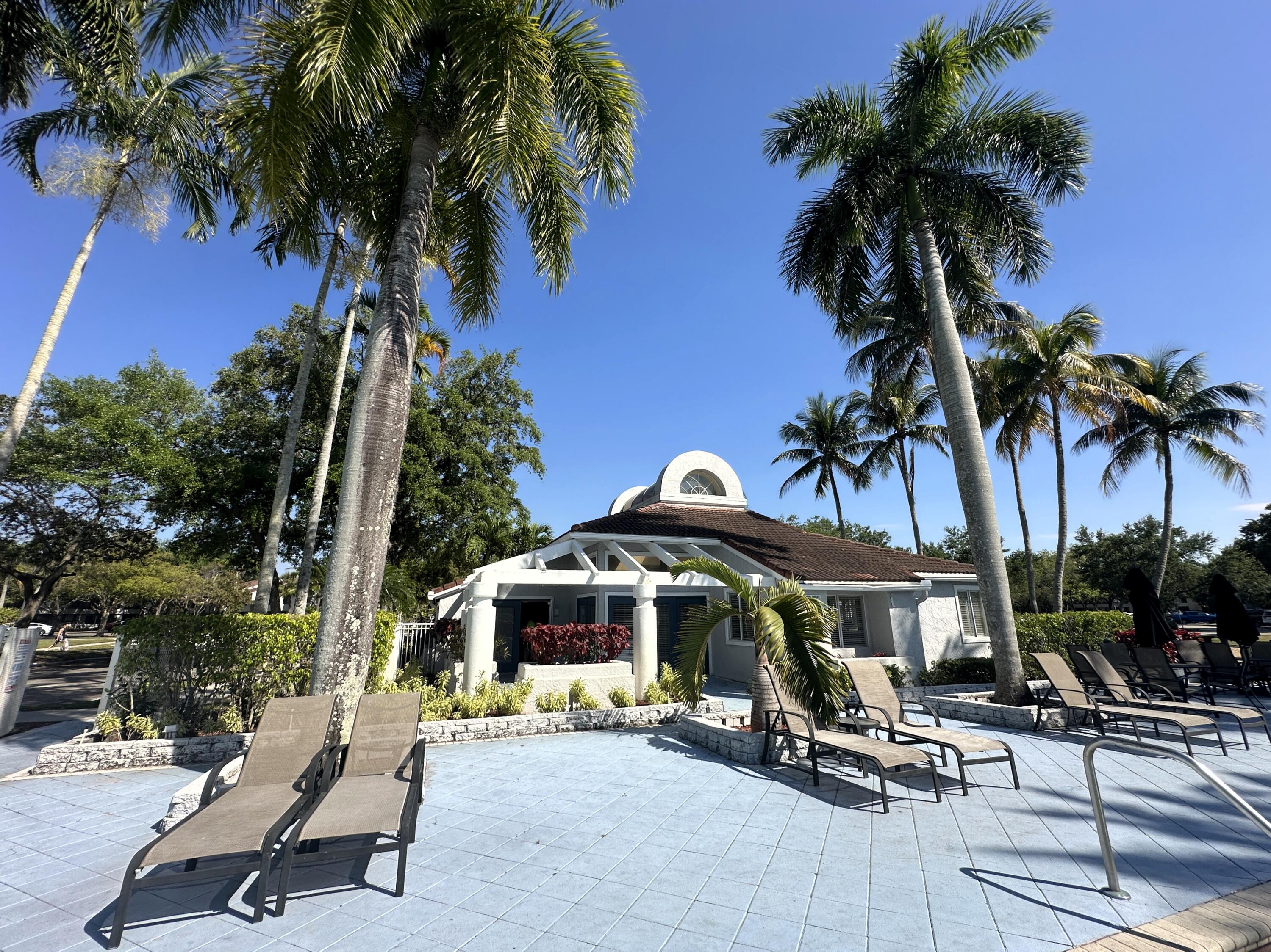 931 Lyons Road, Unit 4201 Coconut Creek, FL 33063 - Photo 29 of 47 a view of a swimming pool with chairs and a table