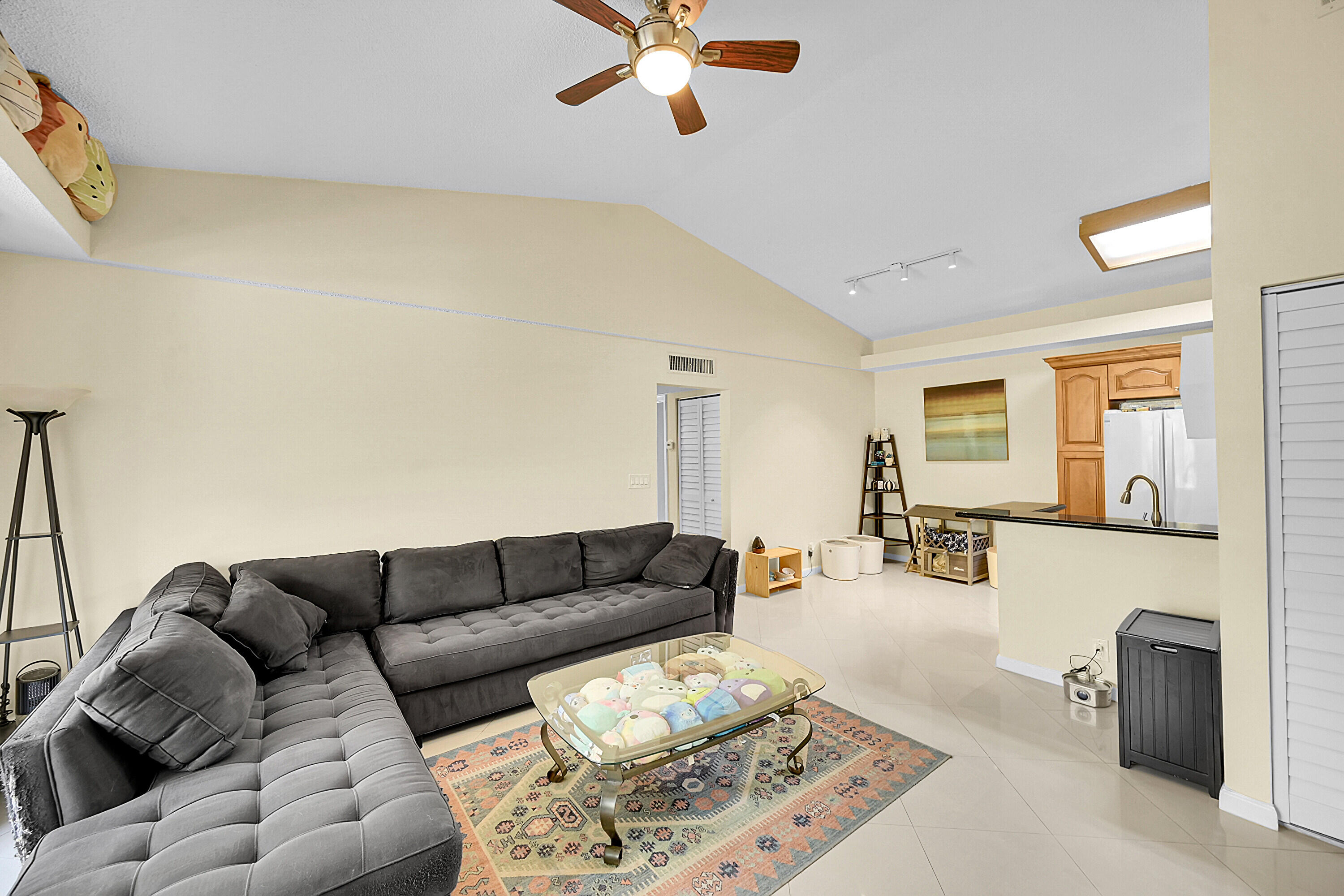 931 Lyons Road, Unit 4201 Coconut Creek, FL 33063 - Photo 3 of 47 a living room with furniture and a chandelier