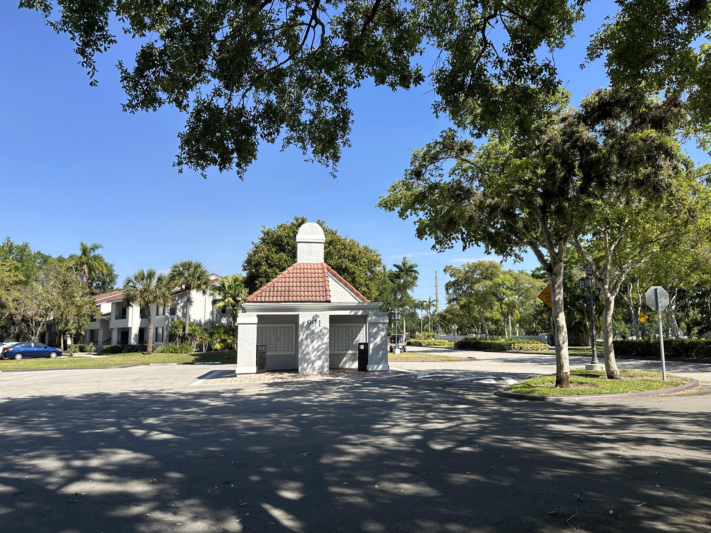 931 Lyons Road, Unit 4201 Coconut Creek, FL 33063 - Photo 32 of 47 a front view of a house with a yard and trees