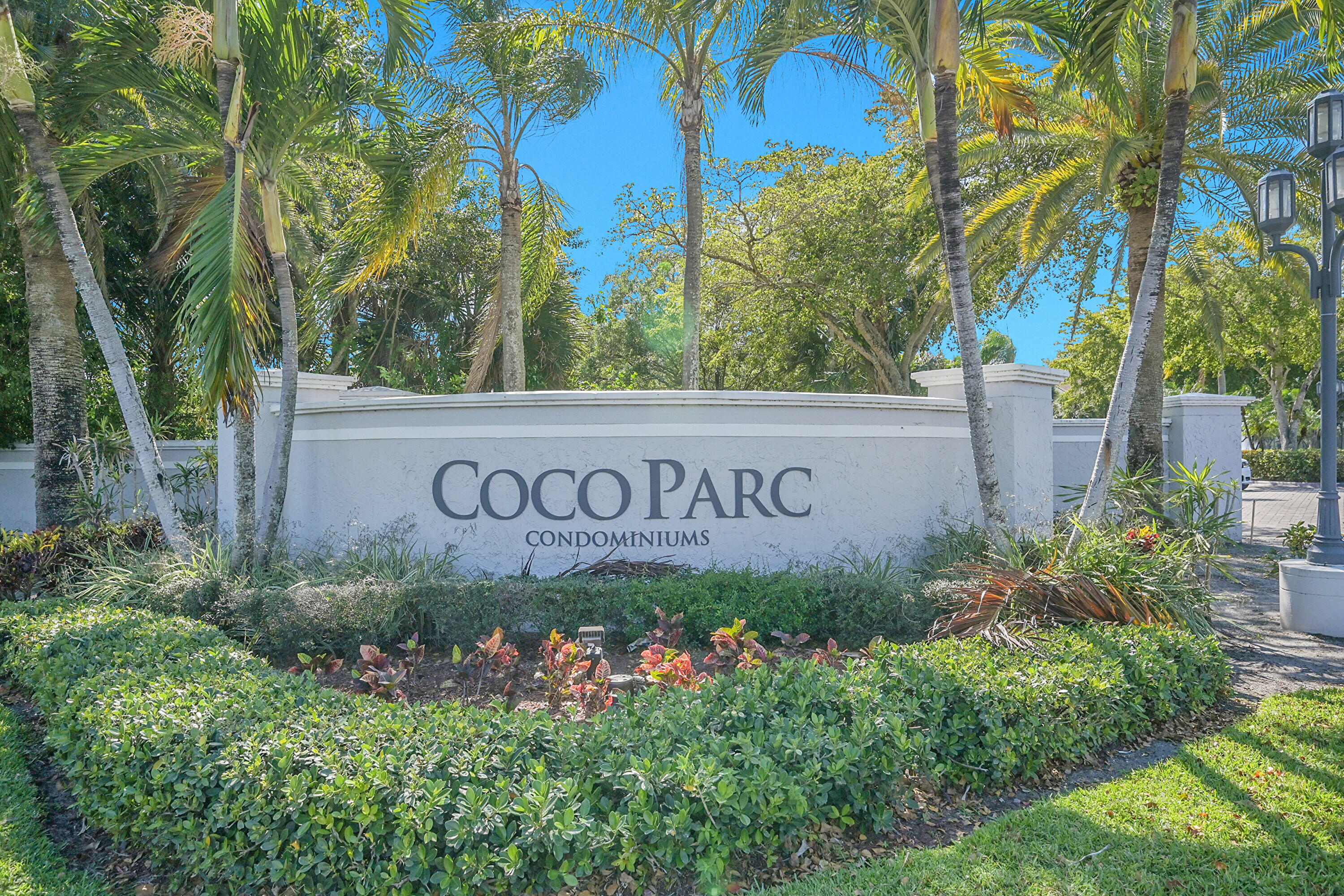 931 Lyons Road, Unit 4201 Coconut Creek, FL 33063 - Photo 43 of 47 a sign broad in front of flowers