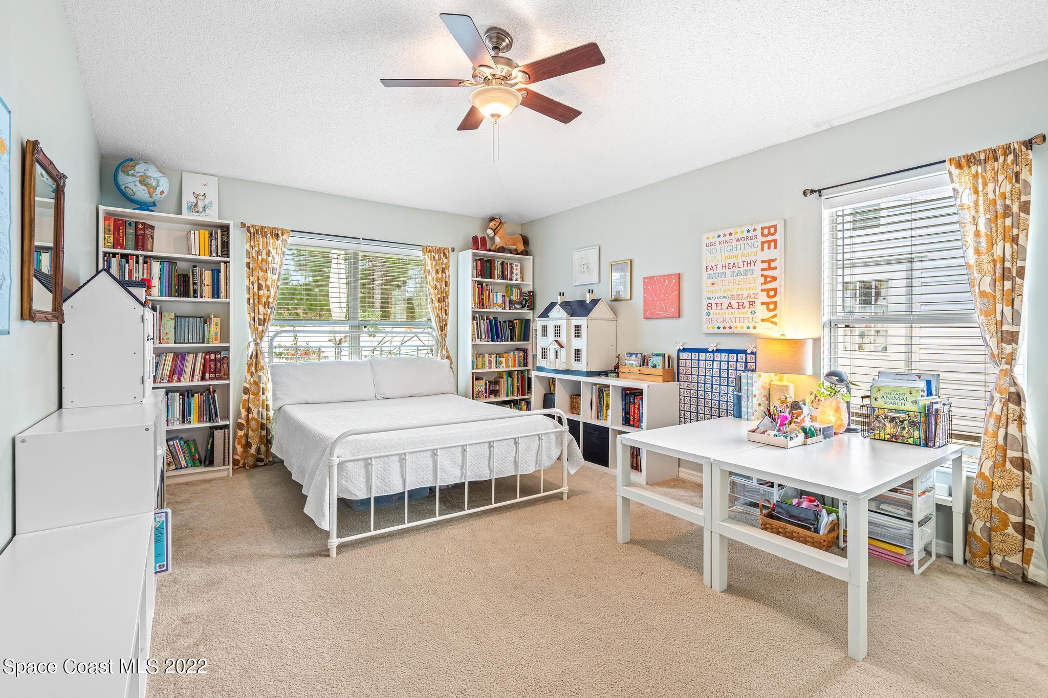 210 Hart Street Southwest Palm Bay, FL 32908 - Photo 8 of 26 a bedroom with furniture and a book shelf