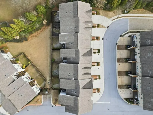 an aerial view of residential houses with outdoor space and parking