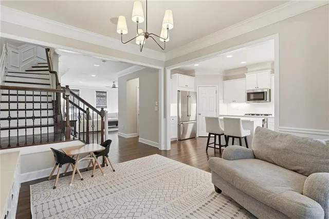a living room with furniture dining table and a chandelier