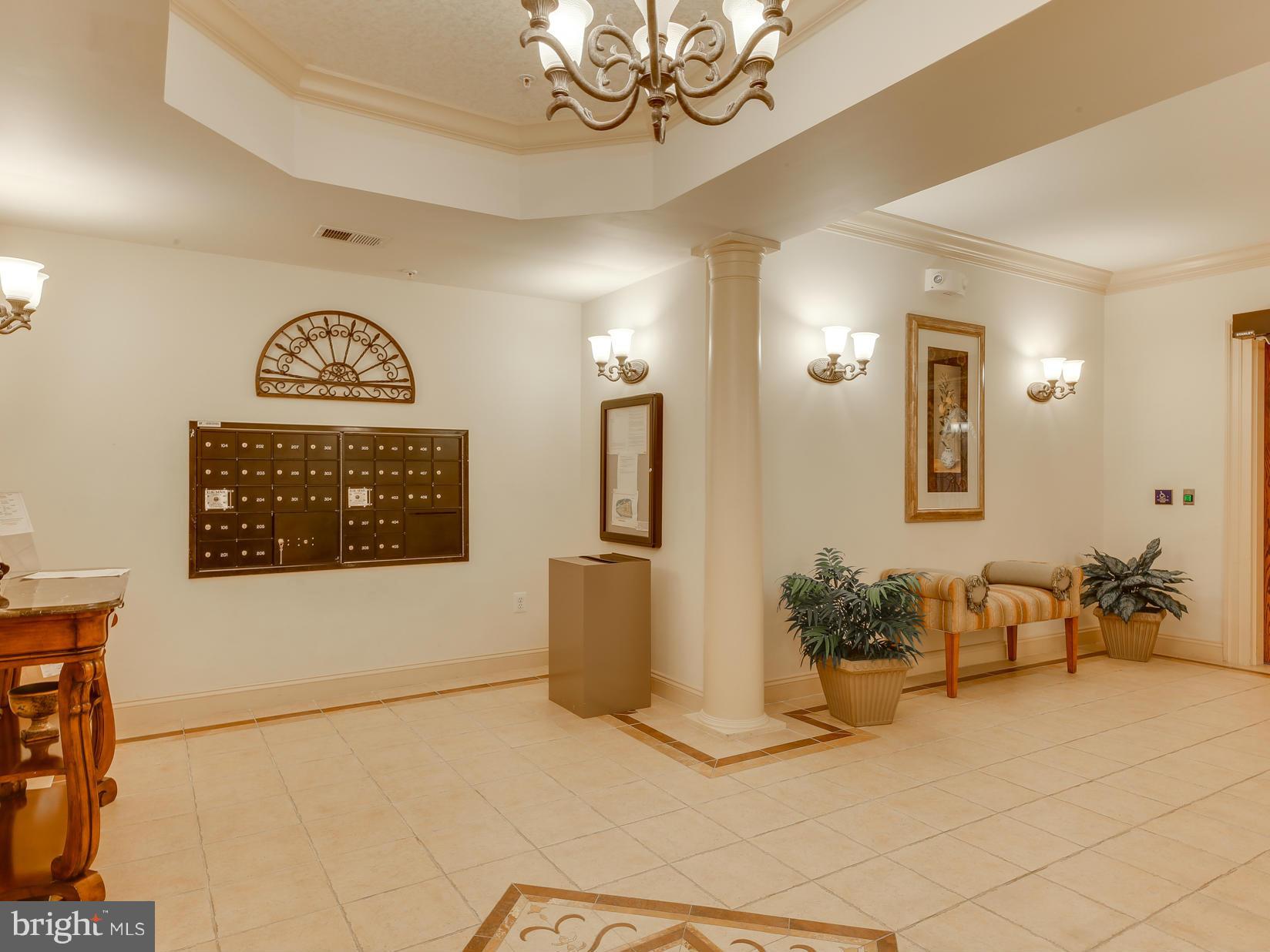 7305 Maplecrest Road, Unit 208 Elkridge, MD 21075 - Photo 5 of 30 a view of a hallway with wooden floor and a chandelier
