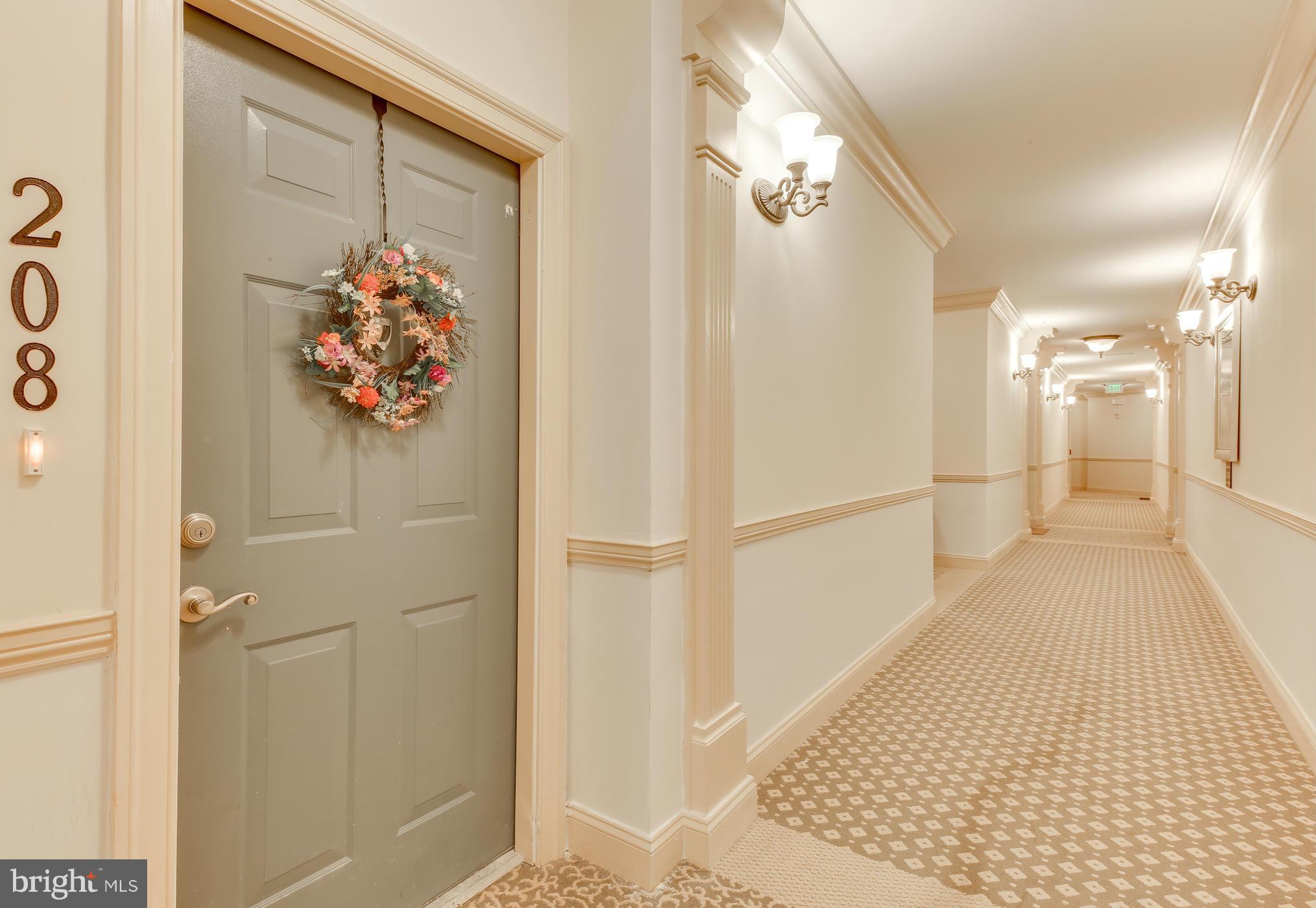7305 Maplecrest Road, Unit 208 Elkridge, MD 21075 - Photo 7 of 30 a view of a hallway with paintings on the wall