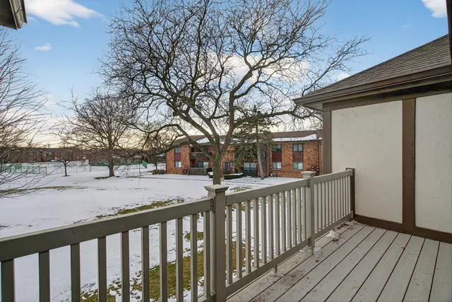 a view of house with wooden deck and a couple of trees