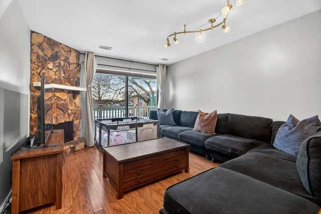 a living room with furniture a flat screen tv and a floor to ceiling window